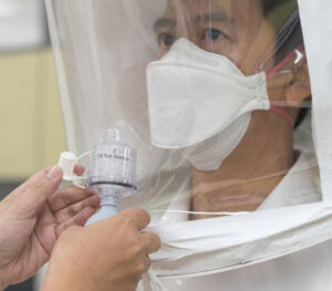 Close-up of a person adjusting a protective mask for a perfect fit