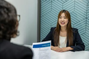 A woman sits at a table examining a medical certificate, relevant to Australian employer leave policies."